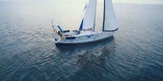 无人机拍摄的白天海上的一艘帆船。