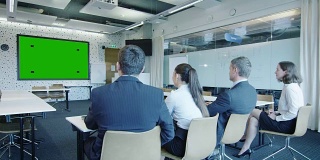 一群上班族在会议室里看绿屏。伟大的模型使用。