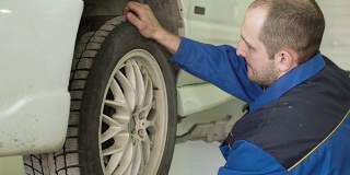 汽车技师正在检查汽车车轮交叉在汽车修理服务
