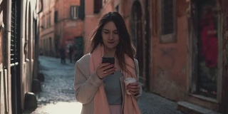 年轻漂亮的女人在城市里走路，还在用智能手机。和朋友聊天喝咖啡的女孩