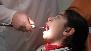 拔牙。牙医为一个小女孩拔牙视频素材模板下载