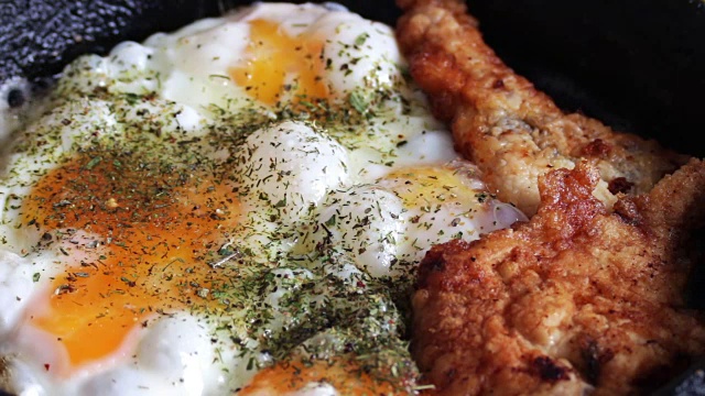 在平底锅里煎鸡蛋和香料炸鸡块