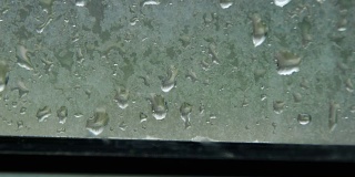 雨滴落在窗户上和雨在塑料窗户后面