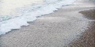 女人美丽的晒黑的腿在沙滩上奔跑。走在海上的女孩