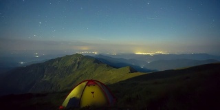 在夜晚繁星满天的背景下，月亮升起和发光的帐篷。喀尔巴阡山脉,乌克兰。