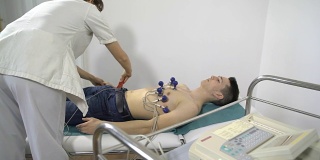 男病人躺在病房附近做心电图