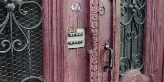 女性的手在用密码锁输入旧门上的密码