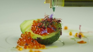 在豪华餐厅用牛油果和橄榄油装饰红鲑鱼鱼子酱视频素材模板下载