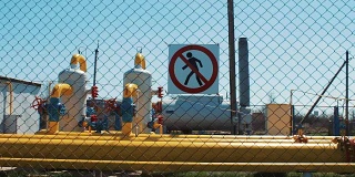 石油工业。天然气和石油的提取和加工。危险的警告信号。禁止未经许可进入。用于抽运天然气的泵站。带有压力计和截止阀的管道。石油行业