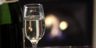 在酒店的bokeh豪华壁炉前的香槟玻璃