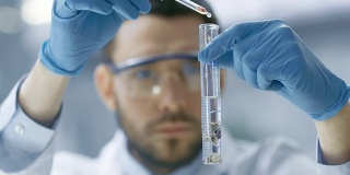 在一个现代实验室科学家通过在试管中使用滴管和植物合成化合物进行实验。