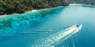 一艘快艇在缅甸nyuang oo phee岛蓝色海水上行驶