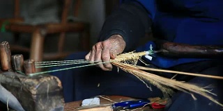 亚洲祖母在家里做传统的草鞋