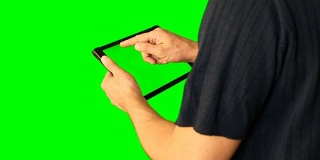 男人使用绿色屏幕的平板电脑在大屏幕上翻倍。