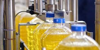 葵花油加工厂。工业机器拧紧塑料瓶的瓶盖。4 k。