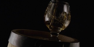 白兰地酒杯放在木桶上。黑色背景。缓慢的莫