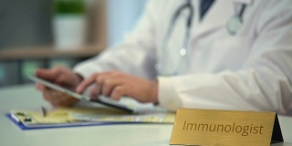 男性免疫学家用触屏平板电脑查看医疗记录