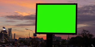 繁忙街道上的一个绿屏广告牌。