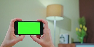 男性手持绿色屏幕的手机