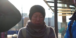 一对亚裔老年夫妇在阿姆斯特丹等电车。退休后自己环游世界