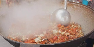 龙虾在大锅里煮。街头美食节的海鲜烹饪过程。小龙虾在大锅中煮。厨师在一个大锅里准备龙虾，特写