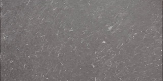 冬天的天气——深灰色的柏油路上下雪