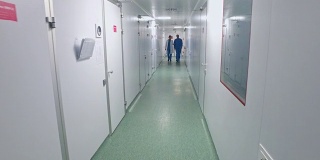 科学家们走在实验室走廊上。制药工人在实验室走廊