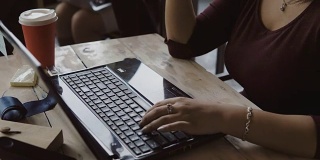 近距离观察年轻的非洲女设计师在笔记本电脑工作。女商人使用电脑，在键盘上打字