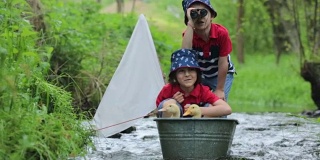 可爱的孩子们，男孩兄弟，在小河上玩船和鸭子，航行和划船。孩子快乐，童年幸福理念