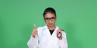 女亚裔皮肤黝黑医生与眼镜，听诊器，转身微笑和拇指欢呼