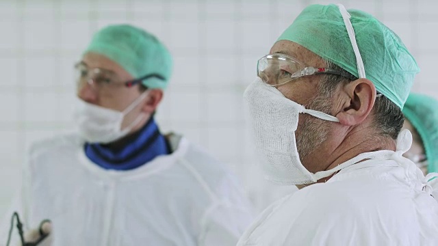 4K两名身穿医疗服、戴着口罩的医生进行腹腔镜下腹部手术。