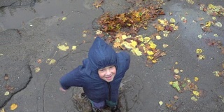小男孩在泥泞的水坑里跳，慢镜头250帧/秒