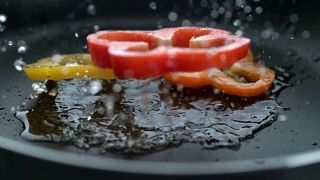 甜椒片倒入热油，慢动作视频素材模板下载