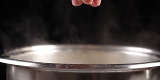 金属锅中加入盐到沸水中，慢动作