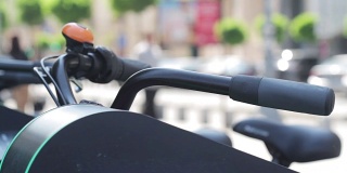 close up of bicycle handle with people walking in the background