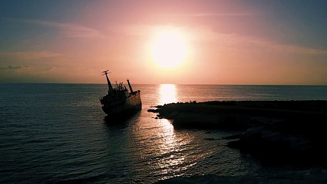 海面上平静的日落。事故后的旧船。地中海。海景与鸟类