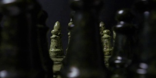 象棋特写，木制棋盘，商业概念，黑色背景。幻灯片。象棋棋子在棋盘上的缓慢滑动运动。棋子的细节在黑色的背景上