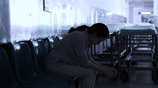 一个亚洲女人独自坐在医院里。担心和焦虑从想到坏消息4K视频素材模板下载