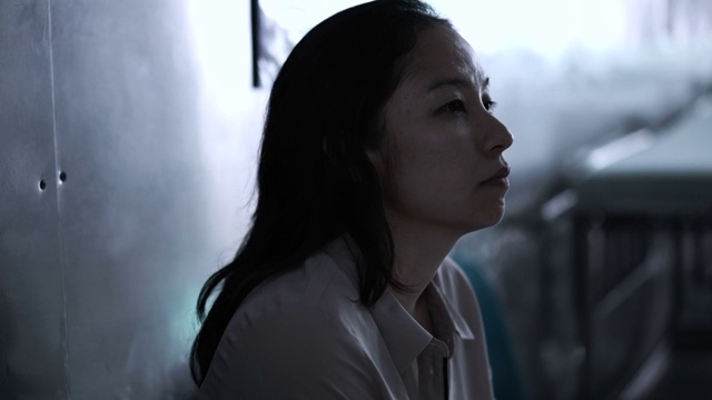 一个亚洲女人独自坐在医院里。担心和焦虑从想到坏消息4K