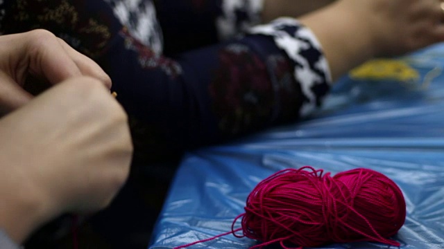 女人们用纱线手工制作曼荼罗，这是制作曼荼罗的古老创意技术