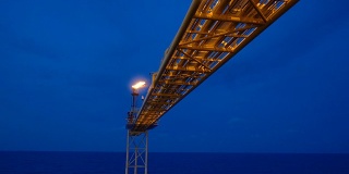 石油和天然气平台与火炬燃烧桥的镜头与日出和美丽的云在早晨的石油和天然气行业的概念。