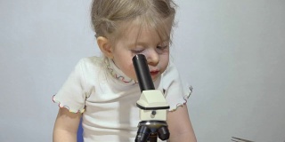 一个男孩和一个小女孩正在显微镜下接受检查。