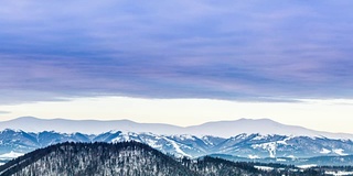 山峰上的雪被风吹走了。冬天的风景。天很冷，下着雪。