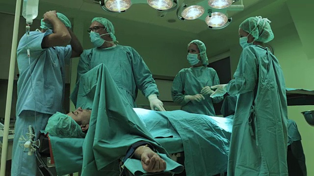 一群忧心忡忡的外科医生在手术前谈论病人的健康问题。