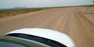 汽车前面的观点驾驶弯曲的沙漠道路
