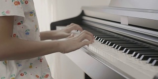 4K:亚洲女孩弹钢琴的慢镜头