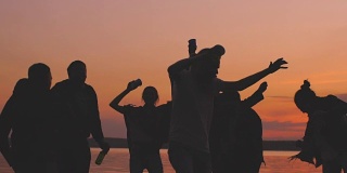 日落时分，一群年轻的舞者在海滩上开派对