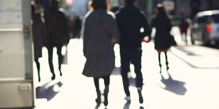模糊拍摄的匿名日本人走在美丽的阳光十字路口和步行街在东京