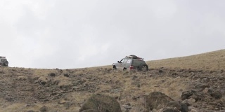 远征越野车在崎岖的山路上缓慢行驶。