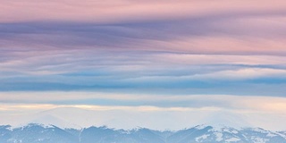 山峰上的雪被风吹走了。冬天的风景。天很冷，下着雪。